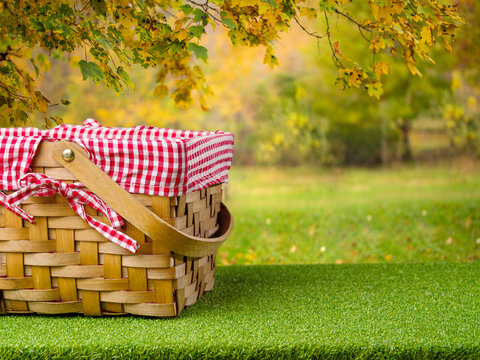 Beautiful autumn nature. On a green lawn, a straw picnic basket. Family vacation, thanksgiving holidays, harvest day, romance, vacation with friends, outdoor walks, picnic, healthy food.