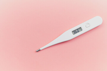 Digital white thermometer with a normal temperature of 36 degrees centigrade on a pink background...
