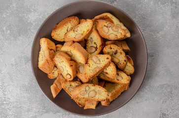 Traditional Italian cantuccini cookies with almonds on a plate on a gray concrete background. Top view.