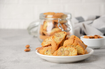 Traditional Italian cantuccini cookies with almonds on a plate on a gray concrete background. Copy space.