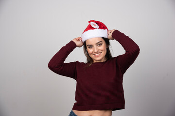 Photo of young woman in Christmas hat looking at the camera