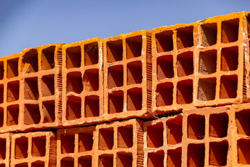 Detalhe de tijolos empilhados.
Tijolos cerâmicos dispostos em pilhas e armazenados ao ar livre...