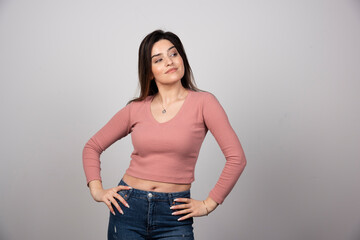 A young woman with long hair standing with hands on hip