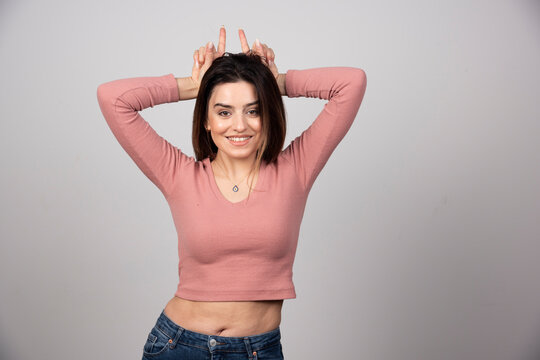 Portrait Of Happy Funny Girl Showing Bunny Ears With Fingers