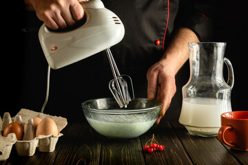 The chef prepares an egg omelette with milk using a hand-held electric mixer. Delicious breakfast...