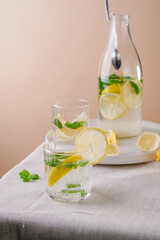 Refreshing summer drink with lemon and mint on the table. Lemonade in glasses and bottle