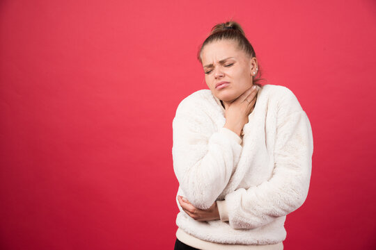 A Young Woman Holding Throat And Suffering From Pain