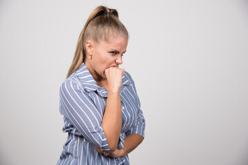 Portrait of woman feeling angry on gray background