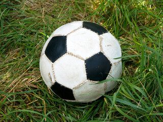 Black and white soccer ball lies in the grass, close-up