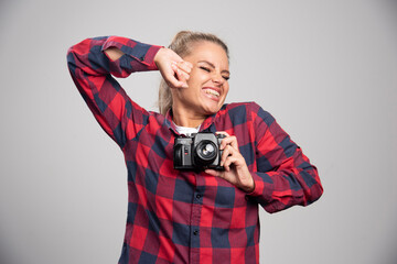 Blonde photograph in checked shirt taking photos and feels positive