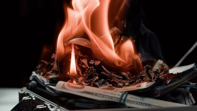 Burning American hundred dollar banknotes, Flame of fire from money. Rich person having stacks of 100 US dollars in metallic suitcase. Paper money loss, financial crisis and depressed economy. 