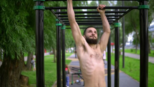 A man of Arab appearance on pull -up bars does exe