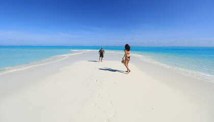 man and girl on white sand beach on tropical island
