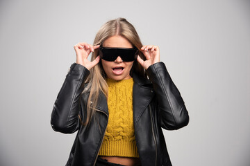 Blonde celebrity in black sunglasses looks confident and proud of herself