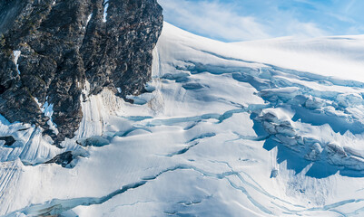 An aerial view of snow and crevasses on the peaks above the Denver glacier close to Skagway, Alaska in summertime