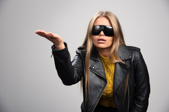 Blonde celebrity in black sunglasses looks upset and agressive