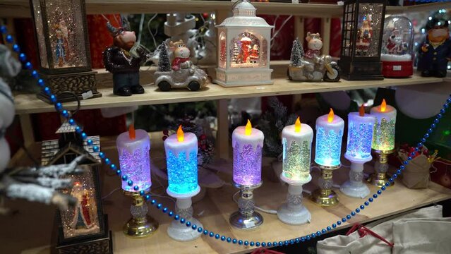 Various decorations for the house. Candles glowing at the Christmas market. Focused image of Christmas and New Year decorations in the store.The concept of purchasing gifts. High quality 4k footage