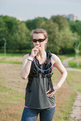 Beautiful fitness woman drinking water from the tube of hydropack