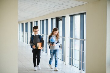 Happy school kids in corridor at school