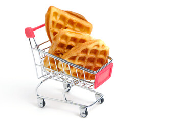 Soft waffles in shopping cart on white background.