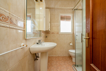 Bathroom with white wood-framed mirror, glass-enclosed shower stall, and white porcelain toilets