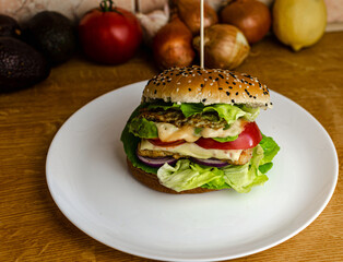 hamburger on a plate, food on a plate, hamburger with chicken, lettuce, tomato, avocado, onion