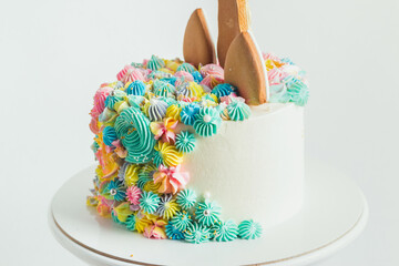 gingerbread cookies on the top of birthday cake decorated with cream cheese flowers. Colorful cake for a little girl on the white background