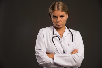 Blonde female doctor with a stethoscope looks agressive