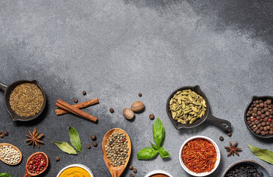 Assortment of aromatic herbs and spices on grey rustic background with copy space for your design top view.