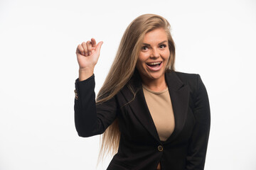 Young businesswoman in black suit looks positive and pointing at something