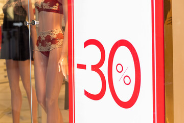 Discount percentage sign display in fashion department store.Sale tag of offering special promotion hanging in shopping mall.Promotion of 30 percent discount ,red banner background