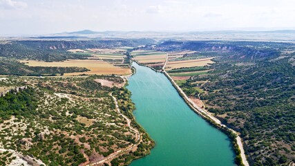 Obraz premium Aerial view of the dam pond between agricultural fields 