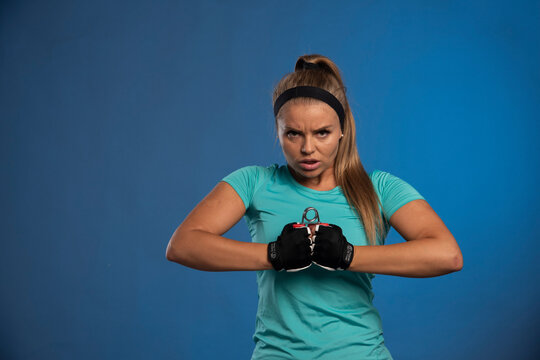 Young sportive woman holding a hand stretching gum and and stretching it with both hands