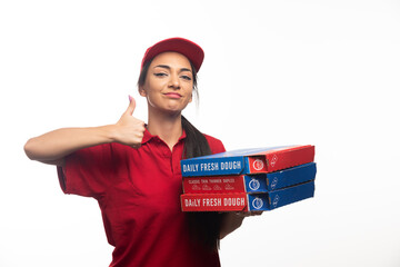 Deliverywoman with thumb up carrying a cardboards of pizza