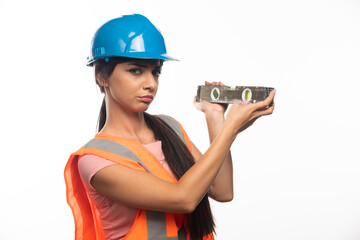 The young charming girl the builder with the measuring tool on white background