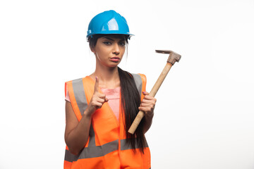 Woman wearing in vest and helmet holding hammer