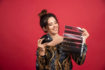 Brunette girl checks her photo history on polaroid film and looks satisfied