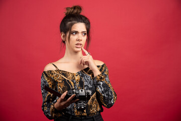 Brunette photograph girl checks her photos in the camera and looks dissatisfied