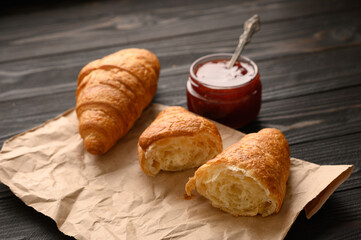Tasty and delicious croissants with jam on a wooden table