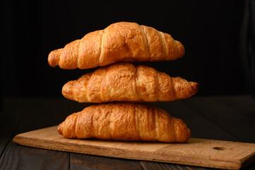 Fresh croissants on a wooden background.
