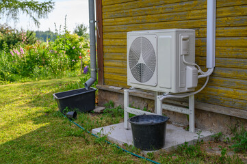 An air conditioner and an air source heat pump are installed on the exterior facade of the old...