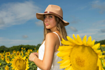 A Lovely Blonde Model Poses Outdoor While Enjoying The Summer Weather In A Field Of Wild Sunflowers