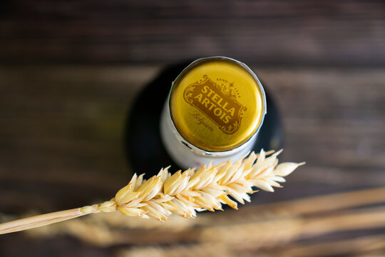 June 22, 2022 Ukraine city Kyiv, glass bottle of Stella Artois beer, ear on old background