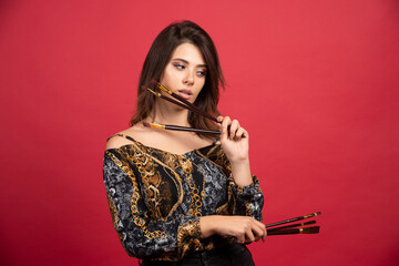 Artist girl looks at her set of new brand brushes and thinking about new projects