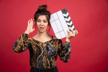 Girl with a clapper board can not hear or understand anything and asks for attention