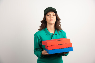 Delivery woman with pizza boxes posing on white background