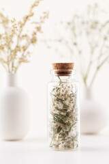 Dried herbal flowers with bottle. Homeopathy background.