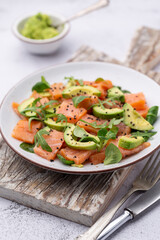 Fototapeta na wymiar Salmon salad with avocado, for keto and low carb diet. Rusty background, top view, copy space.