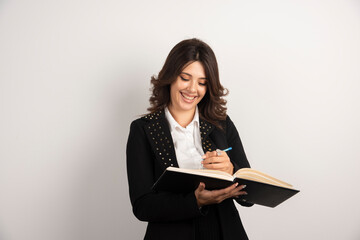 Fototapeta premium Positive teacher writing notes for her class