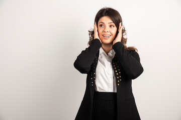 Surprised woman in black jacket covered her ears